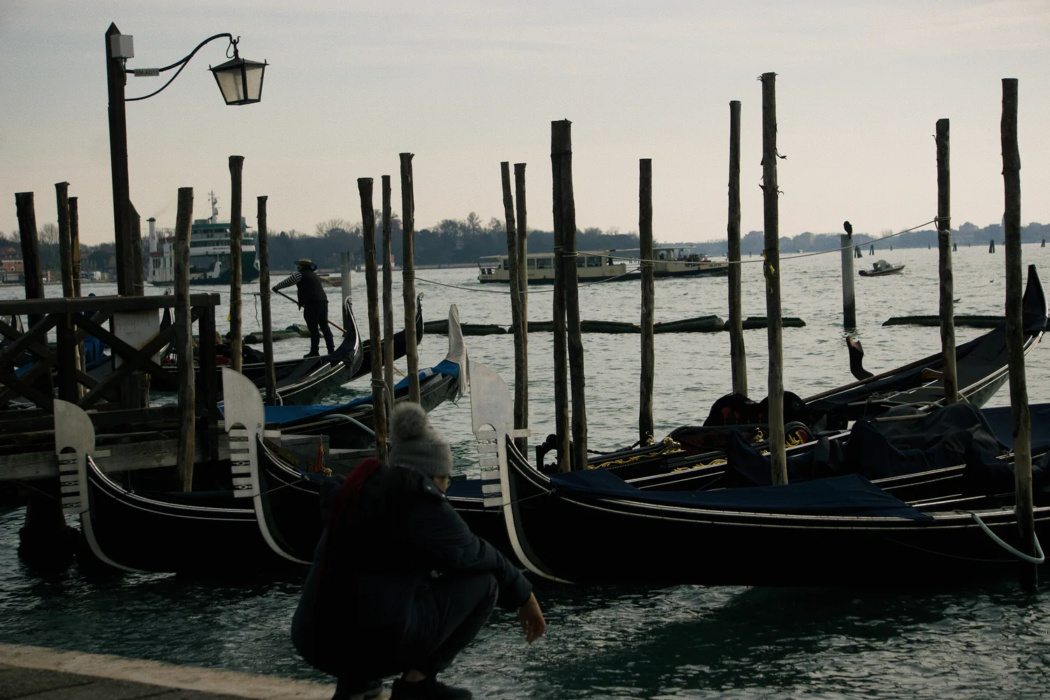 Góndolas amarradas y postes de madera al atardecer, Venecia