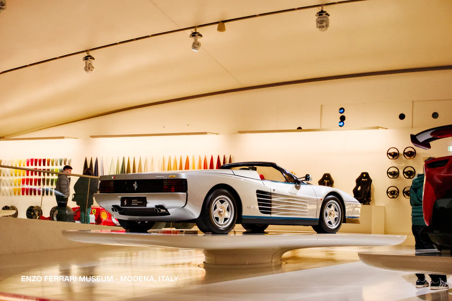 Ferrari blanco en exhibición bajo luz cálida, Museo Enzo Ferrari