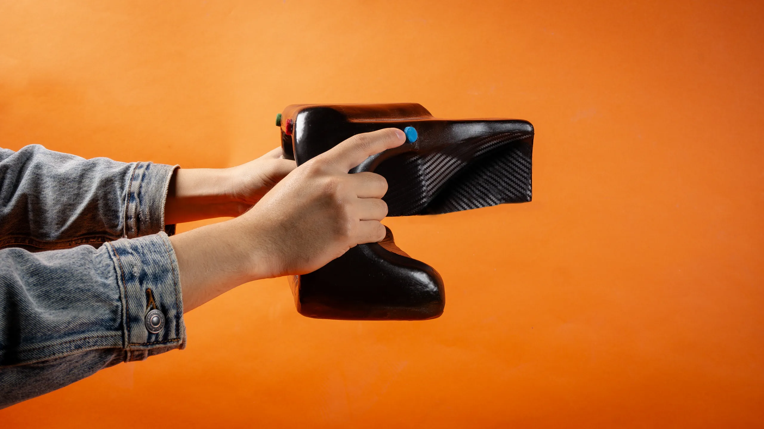 Proxima held from the side — thumb reaching button